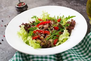 Healthy salad bowl with beef meat, sweet peppers, onions and mixed greens